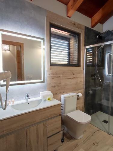 Baño con ducha, toallas y amenities en dormitorio de planta superior en Casa Melide.