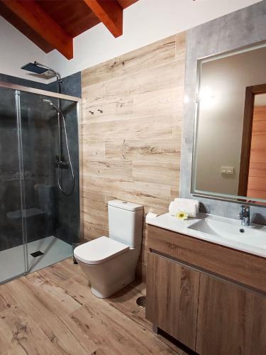 Baño con ducha, toallas y amenities en dormitorio de planta superior en Casa Melide.